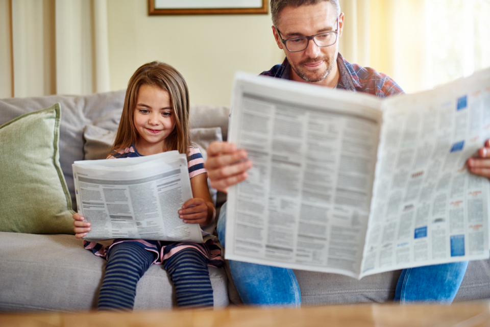 Tochter und Vater lesen gemeinsam Zeitung